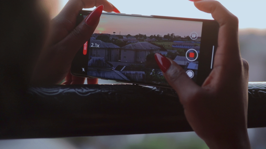 A close-up of a hand holding a Tecno Camon 40 Pro 4G smartphone, capturing a sunset view, showcasing the phone's camera features in use.
