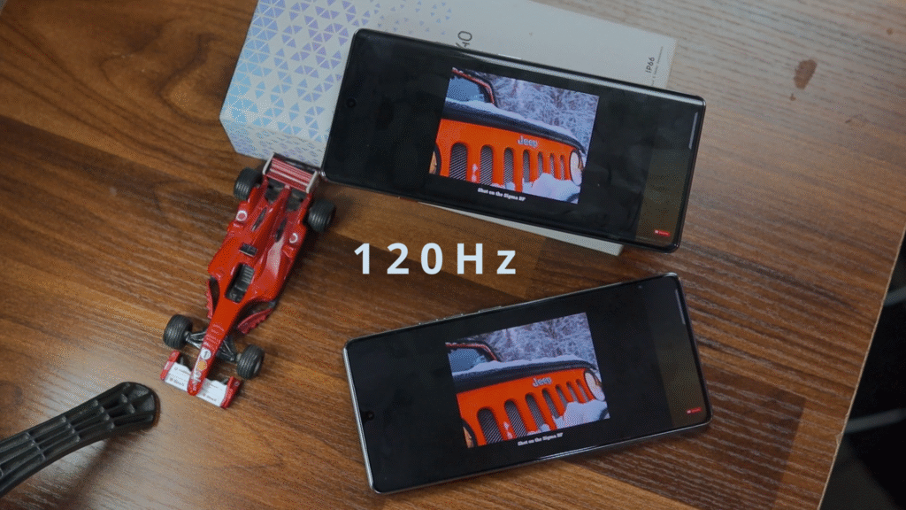 Two smartphones displaying a video on a wooden table, with a toy car nearby and the text '120Hz' prominently featured.